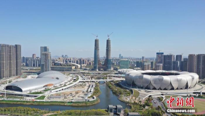 资料图：拍杭州亚运会主体育馆(右)、游泳馆(左)。目前，杭州2022年亚运会主体育馆、游泳馆以及综合训练馆已基本竣工。杭州亚运会期间，“亚运三馆”中的主体育场与游泳馆将承担篮球、游泳、跳水和花样游泳等比赛，综合训练馆则将承担集中训练及医疗、商务等功能。
<a target='_blank'  data-cke-saved-href='//www.chinanews.com/' href='//www.chinanews.com/'>中新社</a>记者 王刚 摄